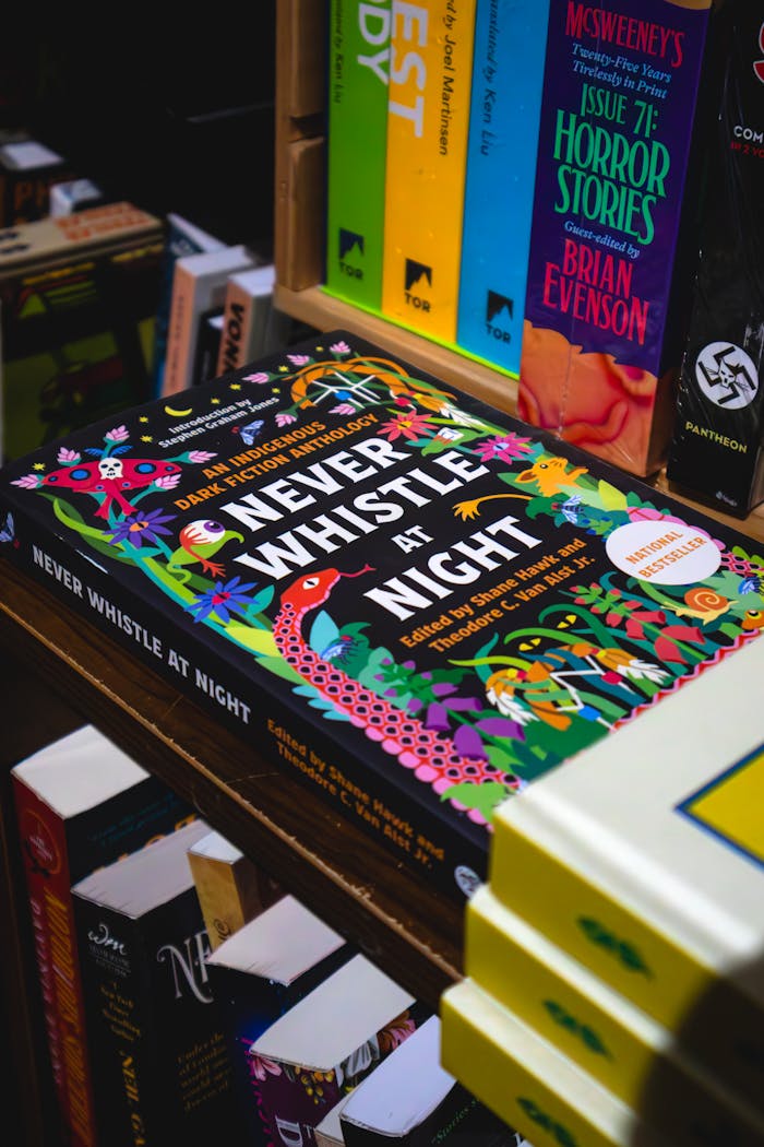 Vibrant book collection showcasing Never Whistle at Night in a Toronto bookstore.